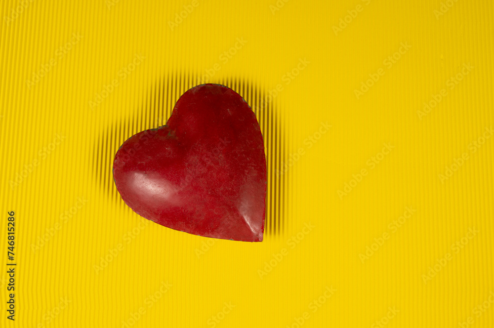 Red color heart on yellow banner with shadows isolated Red color heart on yellow banner with shadows isolated