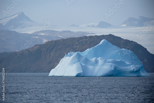 Turquoise iceberg and mainland ice-sheet, East Greenland