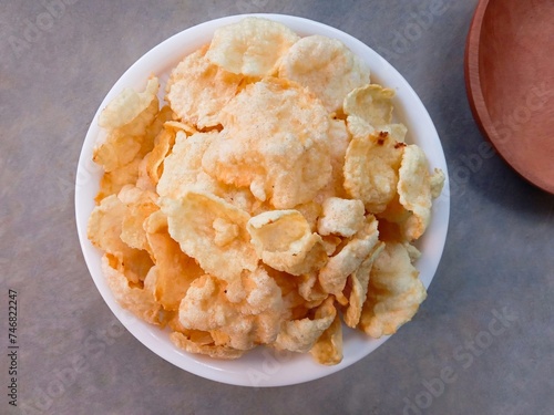 bowl of cereal. Kerupuk emping or emping crackers made from melinjo seeds which are flattened, dried in the sun and then fried. Traditional crackers taste bitter and crunchy. Close up photo