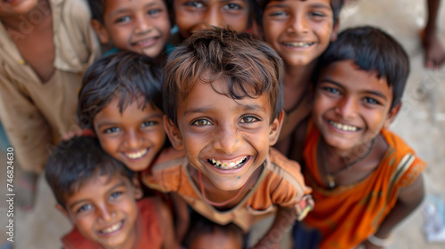 Group of Indian villager boys in a tight group, happy and smiling, looking up.