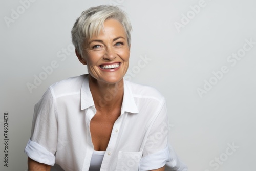 Portrait of a happy senior woman smiling at the camera over grey background