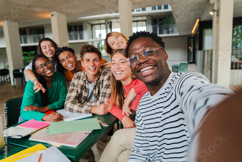 Happy young students taking a selfie portrait together at university library. African american guy shooting a photo with his smiley classmates on a high school meeting. Friends at academy. friendship photo