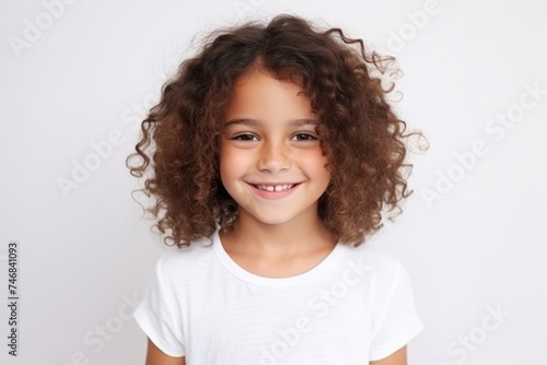 Portrait of a cute little girl with curly hair over grey background