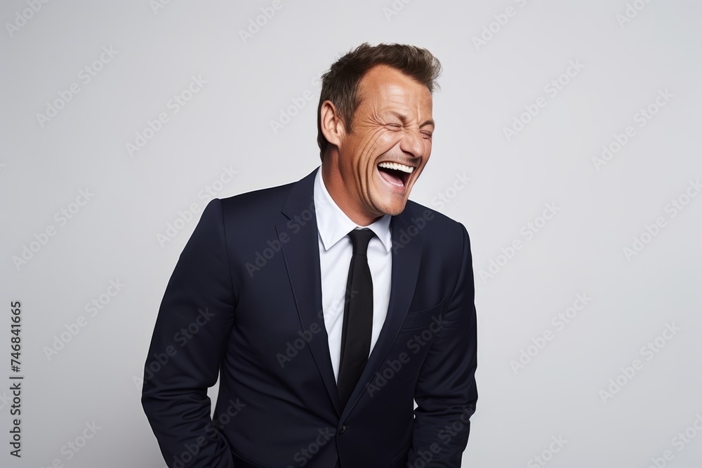 Handsome mature businessman shouting and looking at camera while standing against grey background Handsome mature businessman shouting and looking at camera while standing against grey background