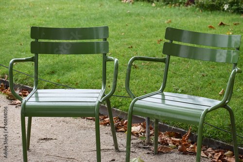 Fototapeta Naklejka Na Ścianę i Meble -  Two green chairs in the park close up