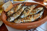 Grilled sardines served with bread on a plate