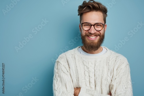 Happy young man with beard wearing casual sweater and glasses standing with arms crossed smiling at the camera Positive demeanor
