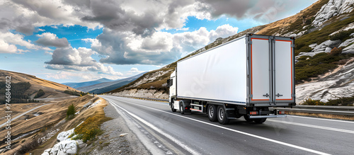 truck driving on the highway through the mountains to deliver merchandise photo