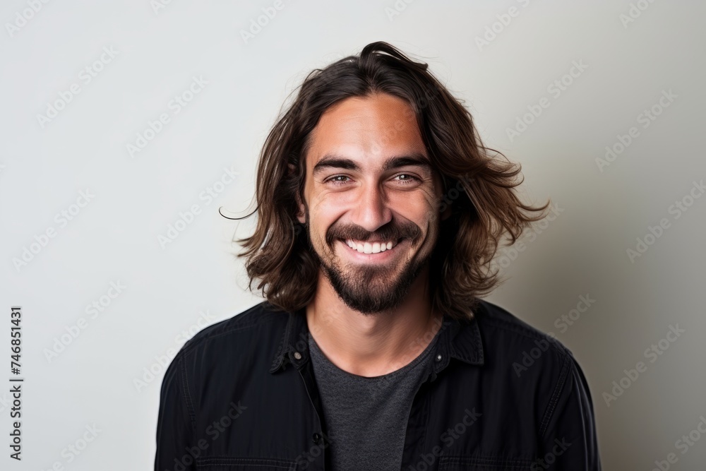 Portrait of a handsome man with long hair smiling at the camera - obrazy, fototapety, plakaty 