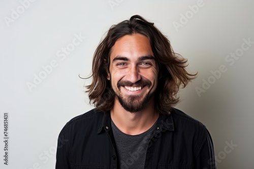 Portrait of a handsome man with long hair smiling at the camera
