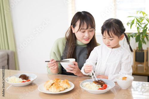 Dinner together is delicious, isn't it? Mother and daughter eating together with a look of "It tastes so good!