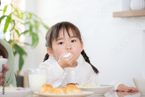 Front of Asian (Japanese) girl sitting and eating at table