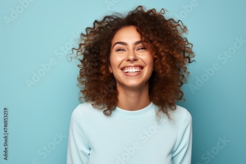 Portrait of a beautiful young african american woman with curly hair on blue background © Inigo