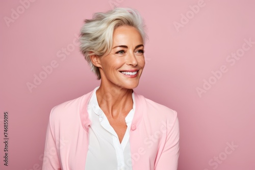 Happy mature business woman. Portrait of beautiful mature businesswoman looking at camera and smiling while standing against pink background