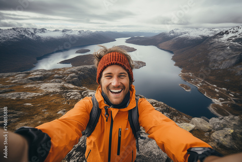 Adventurous man taking selfie on mountain peak photo
