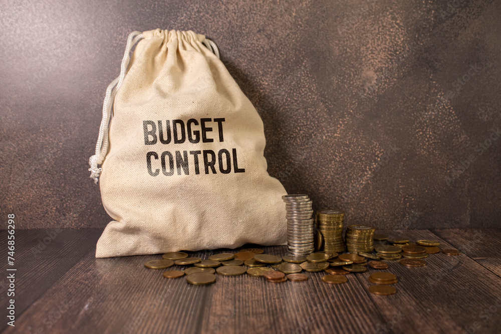 Naklejka premium Budget Control. Burning sheet of paper with text on a rusty metal background.