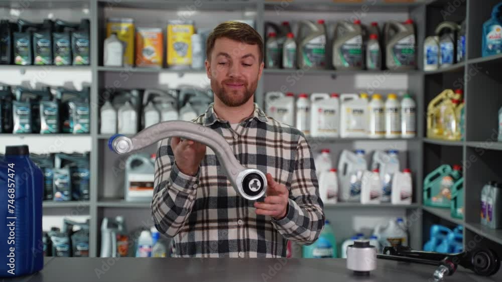 Funny auto parts seller with car spare part in shop Funny auto parts seller with car spare part in shop