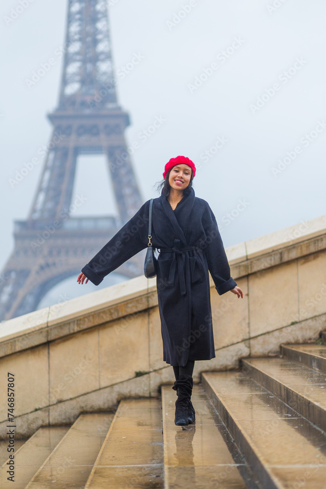 Young beautiful happy woman in red French beret in Paris, France against Eiffel Tower.  European tourism and travels to the capital cities