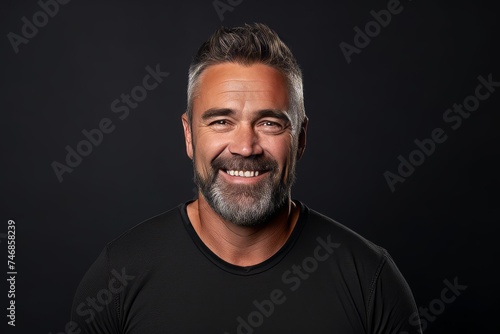 Portrait of a handsome middle-aged man on a black background. © Inigo
