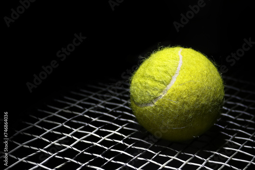 tennis ball on a tennis racket net on a black background