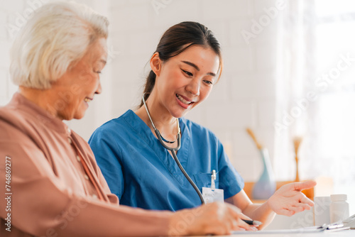 Health insurance service, Young Asian caregiver nurse examine senior man or woman patient at home. Attractive specialist career female support give advise and therapy consult to older elderly mature