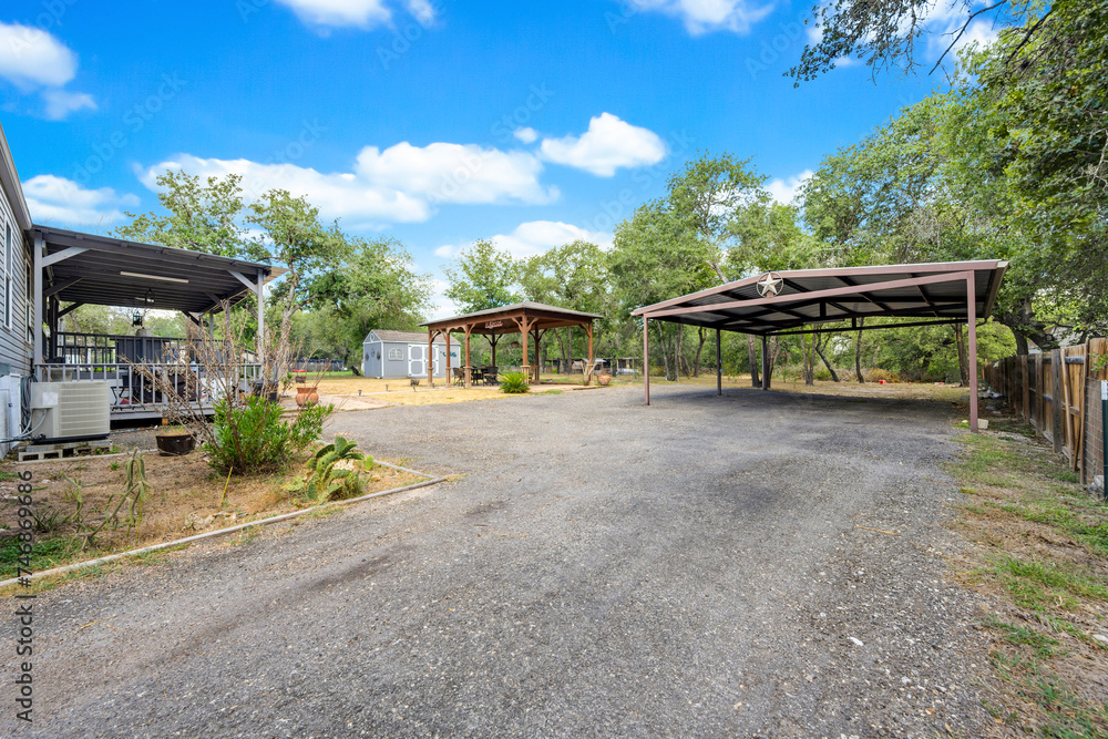 Open space with gravel path and shaded areas in a relaxed outdoor setting during daytime hours Open space with gravel path and shaded areas in a relaxed outdoor setting during daytime hours