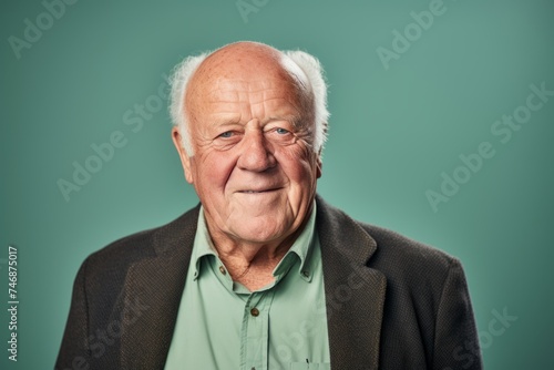 Portrait of an old man with wrinkles on his face. Isolated on green background.