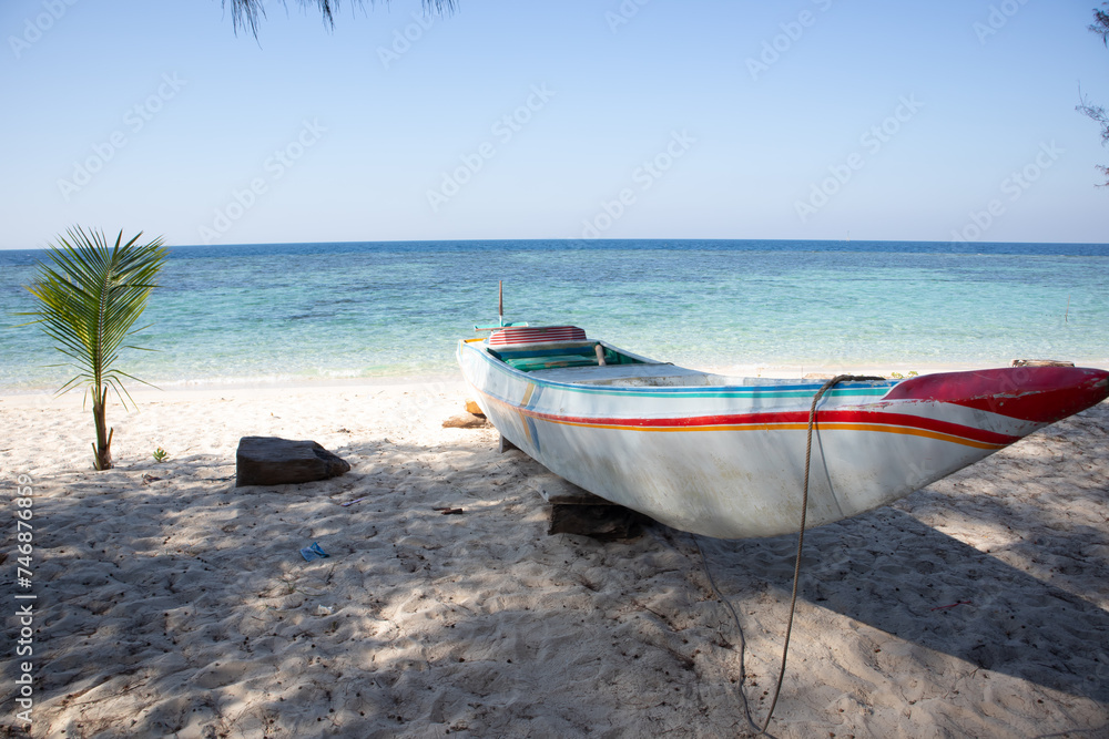 a traditional wooden boat sitting on top of a sandy beach a traditional wooden boat sitting on top of a sandy beach