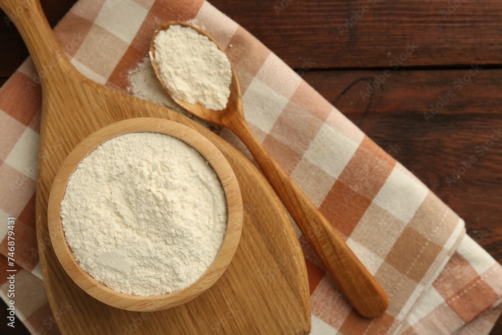 Baking powder in bowl and spoon on wooden table, top view Baking powder in bowl and spoon on wooden table, top view