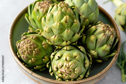 Artichokes on a ceramic plate with a rustic aesthetic.