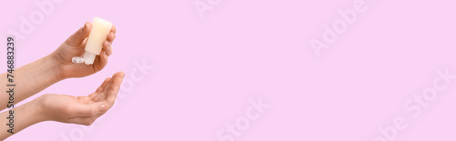 Woman applying sanitizer on her hands against pink background with space for text
