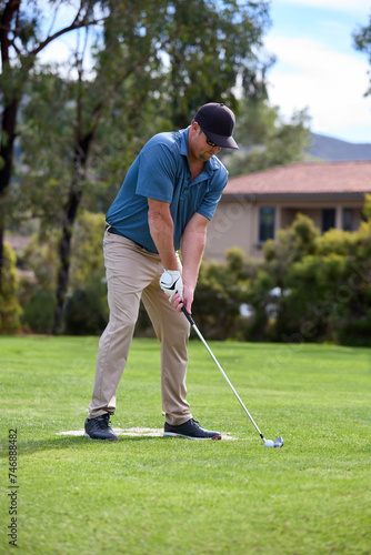 A man lines up a shot on a golf course