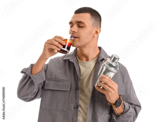 Young male bartender with shaker and glass of cocktail on white background