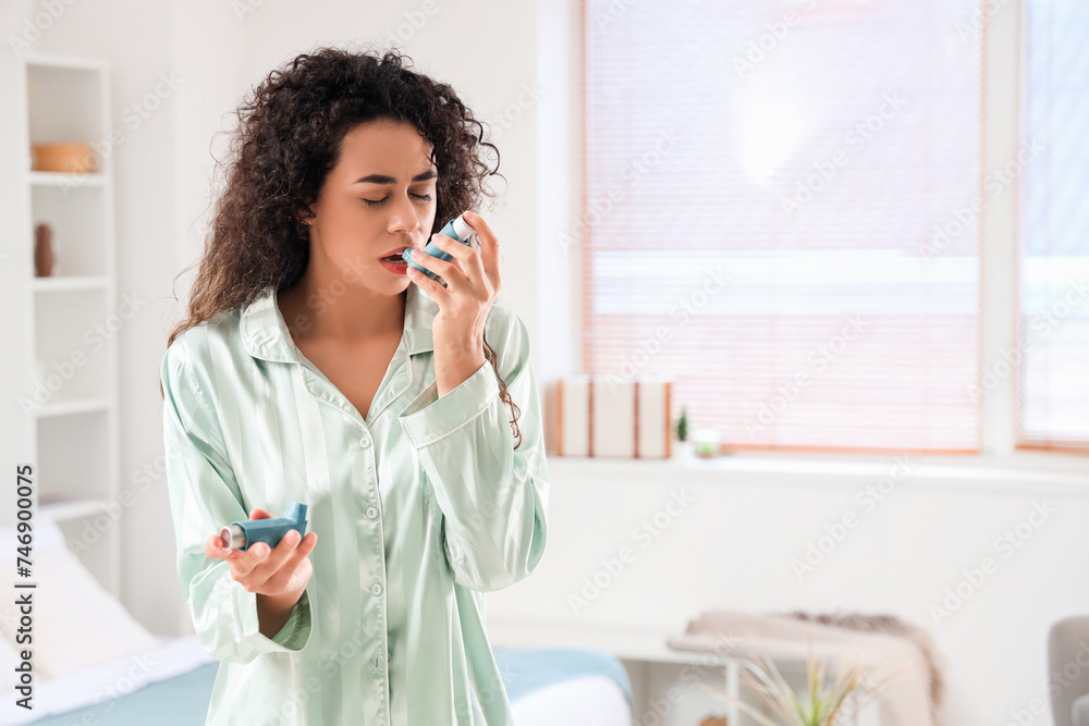 Young African-American woman with asthma inhalers in bedroom Young African-American woman with asthma inhalers in bedroom