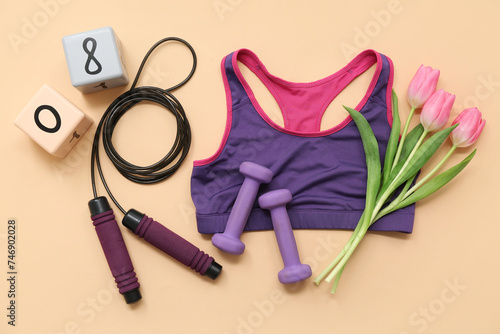 Composition with sports equipment, bra and tulip flowers on color background. International Women's Day photo