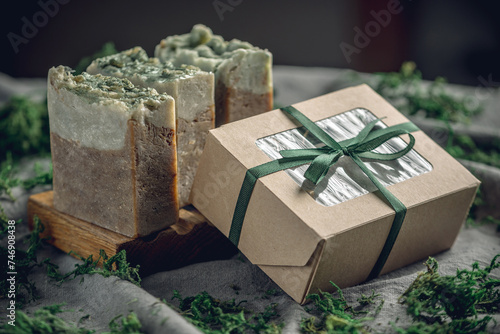 Pieces of authentic craft organic soap on a wooden soap dish surrounded by green moss. Concept of natural cosmetics made from safe, eco friendly ingredients