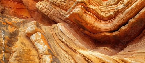 A unique rock formation created by erosion over time stands tall in the desert of Zion Canyon, located in Zion National Park, Utah. The rock formation contrasts against a clear blue sky background.