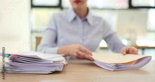Female office worker sorts stacks of documents