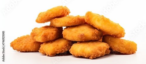 A stack of crispy fried chicken nuggets is displayed neatly on a clean white surface. The nuggets are golden brown and appear freshly cooked, exuding a tempting aroma.