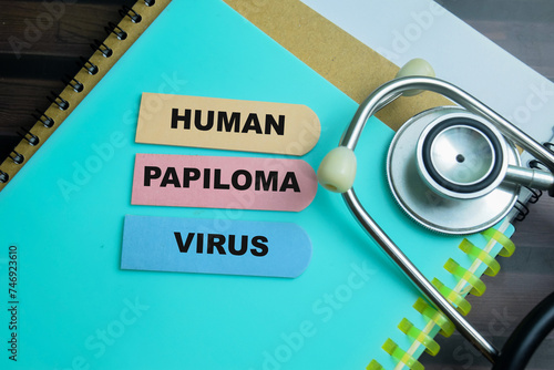 Concept of Human Papiloma Virus write on sticky notes with stethoscope isolated on Wooden Table.