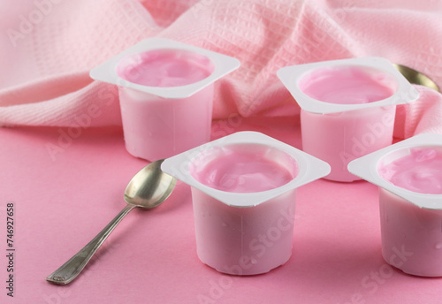 Plastic cups with tasty pink yogurt on pink table - kid's yogurt pots 