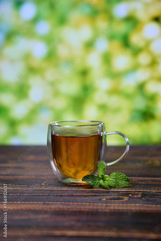 glass cup of natural organic herbal tea on a wooden table glass cup of natural organic herbal tea on a wooden table