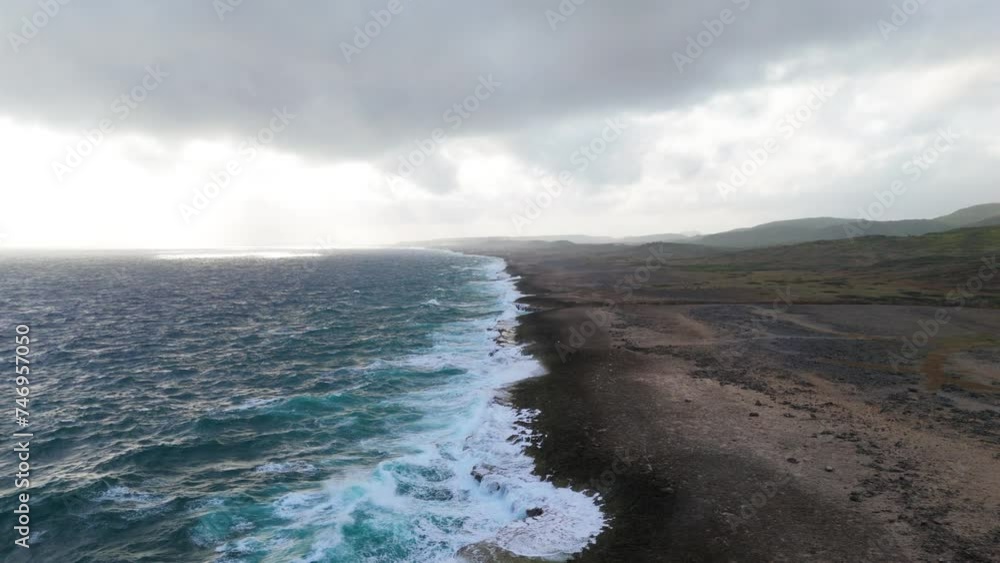 Drone orbit around ocean waves crashing along wide sprawling coastline off to horizon Drone orbit around ocean waves crashing along wide sprawling coastline off to horizon