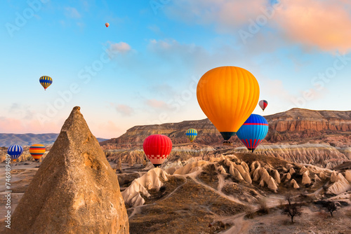Colorful hot air balloons flying over the mountains in Cappadocia, Turkey.