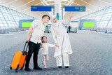 Happy Asian muslim family at the airport