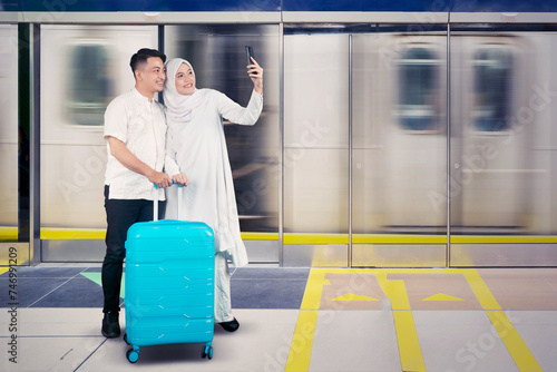 Muslim couple with suitcase showing taking a self portrait