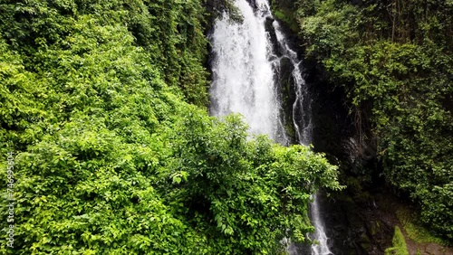 Lush green foliage surrounds a cascading waterfall in Banos, Ecuador