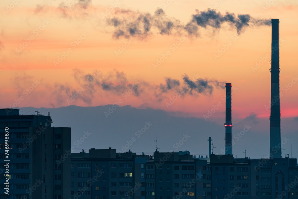 View across the Poland City of Tychy with two chimneys with a sunrise background