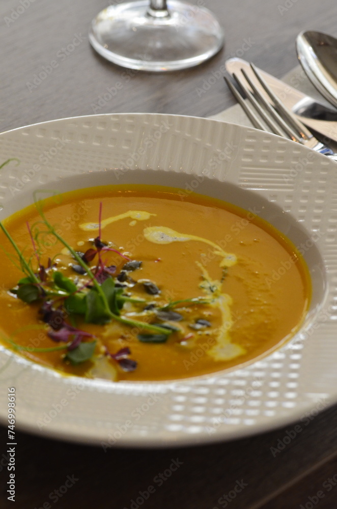 yellow cream soup , with pumpkin seeds, background of delicious healthy food for vegetarians , served food in restaurant yellow cream soup , with pumpkin seeds, background of delicious healthy food for vegetarians , served food in restaurant