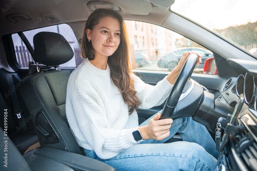 Side portrait of young caucasian woman driving car in the city